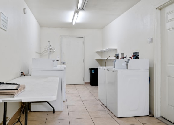 a laundry room with white appliances and a white table  at ReNew Eagle River, Alaska, 99577