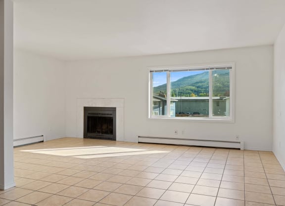 a living room with a fireplace and a large window at ReNew Eagle River, Alaska, 99577