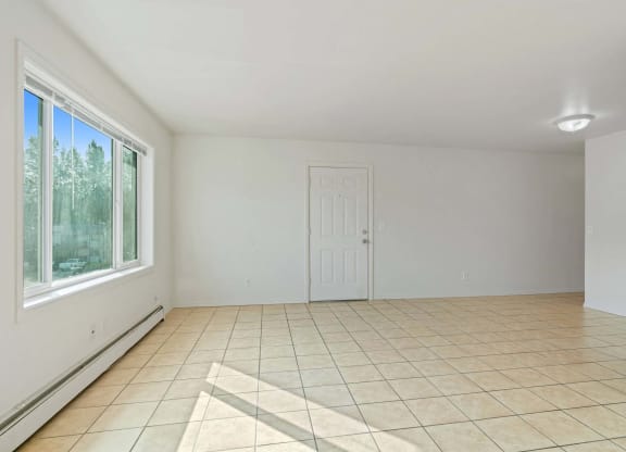 a bedroom with a large window and a tiled floor at ReNew Eagle River, Alaska, 99577