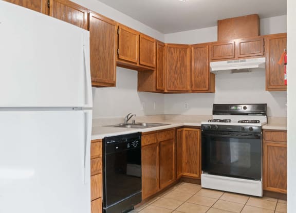 a kitchen with wooden cabinets and white appliances at ReNew Eagle River, Alaska, 99577