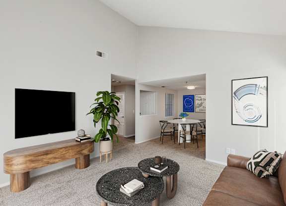 A living room with a brown couch, a coffee table, and a flat screen TV.