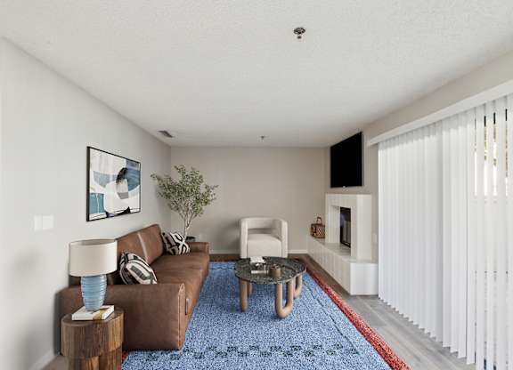 A living room with a brown couch, a blue rug, and a painting on the wall.