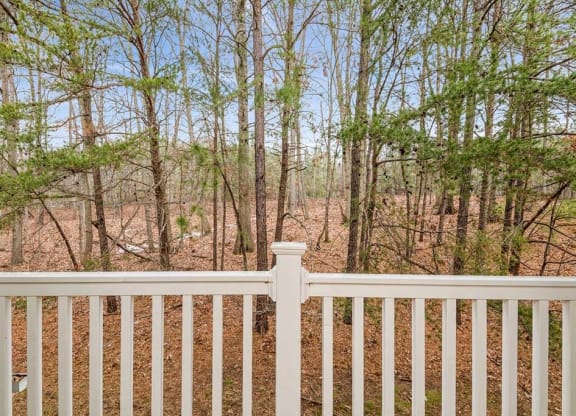 a white fence in front of a wooded area at ReNew Odenton, Maryland, 21113