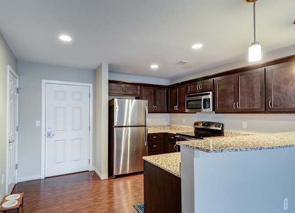 A kitchen with a stainless steel refrigerator and microwave.