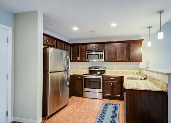 A kitchen with a refrigerator, oven, and microwave.
