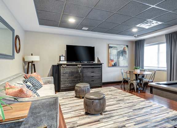 A living room with a pool table and a television.