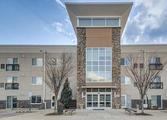 A modern building with a stone pillar in the center of the entrance.