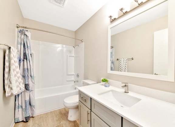 A bathroom with a white sink, toilet, and bathtub. at River Lofts Apartments, Tualatin