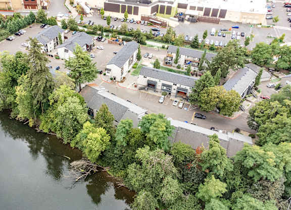 A bird's eye view of a lake surrounded by trees and buildings. at River Lofts Apartments, Tualatin, OR