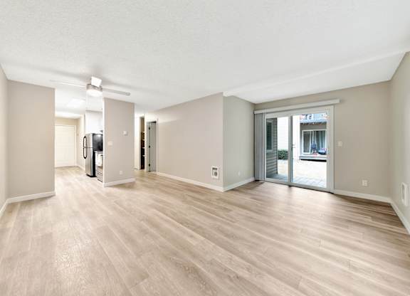 A spacious room with wooden flooring and white walls at River Lofts Apartments, Tualatin 97062