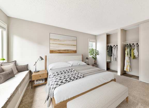 A bedroom with a large bed, a bench, and a wardrobe.