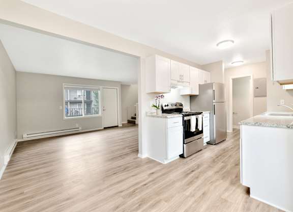 A modern kitchen with white appliances and cabinets. at River Lofts Apartments, Tualatin, OR