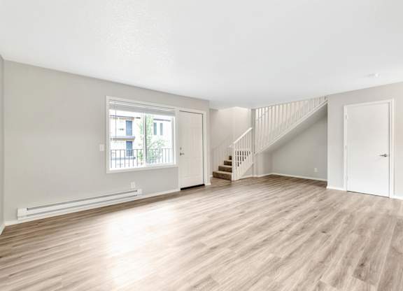 A spacious room with wooden flooring and a staircase. at River Lofts Apartments, Tualatin, OR, 97062