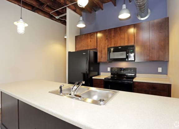 a kitchen with a sink and a black refrigerator