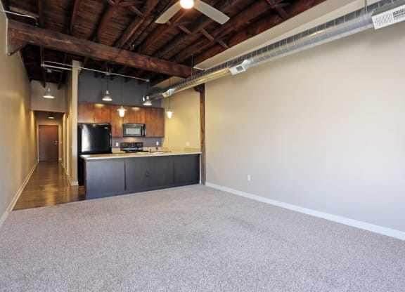 a room with a kitchen and a carpeted floor