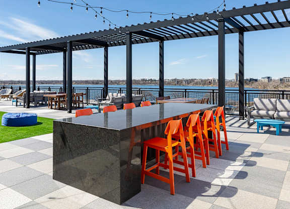 Bar with orange chairs at The Venue on Knox Apartments, Minnesota, 55408