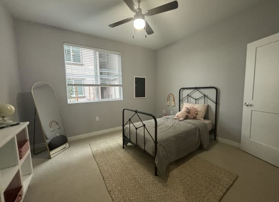 a bedroom with a bed and a ceiling fan