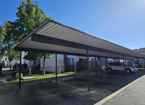 a covered parking lot with cars parked under a canopy at Alturas Paso Robles Apartment Homes, Paso Robles, California