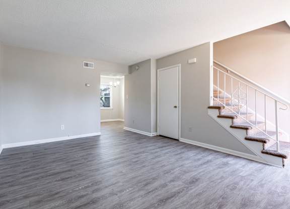 an empty living room with stairs and a door to a hallway at Sharon West, Charlotte North Carolina