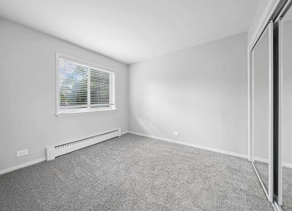 A room with a window and a radiator on the wall.