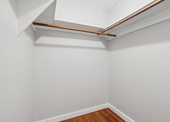 A white room with a wooden floor and a white ceiling with a brown line running across it.