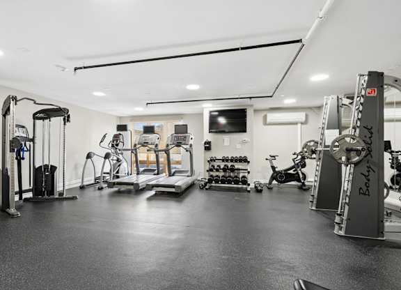 A spacious gym with a variety of equipment including treadmills, weights, and exercise bikes.