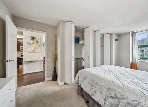 A bedroom with a large bed and a view of the city.