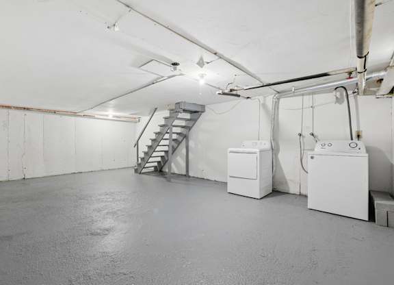A basement with a staircase and a washer and a dryer.