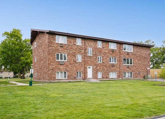 A brick building with a green lawn in front.