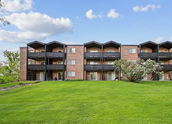 A large grassy area in front of apartment buildings.