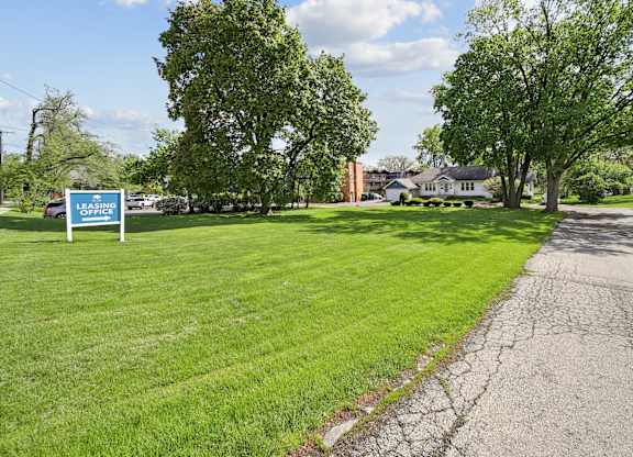 Grass with a leasing office sign