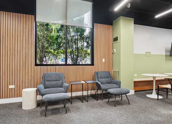 A room with a long wooden panelled wall and a window with trees outside.