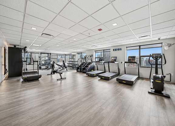 A gym with treadmills, elliptical machines, and other exercise equipment.