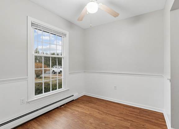 A room with a window showing a white car and trees outside.