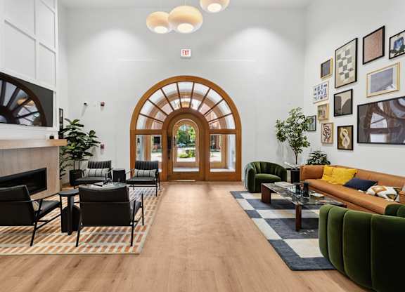 A living room with a wooden floor and a large arched doorway.