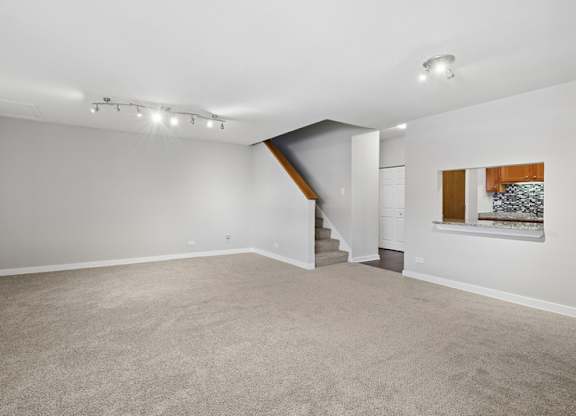 A spacious room with a staircase leading to another level.