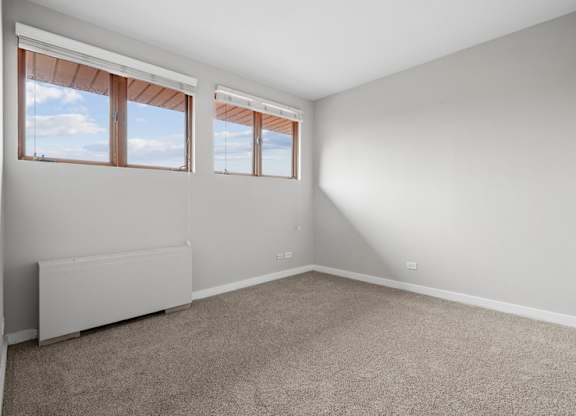 A room with a window and a radiator on the wall.
