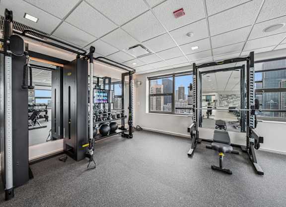 A gym with a view of the city outside the window.