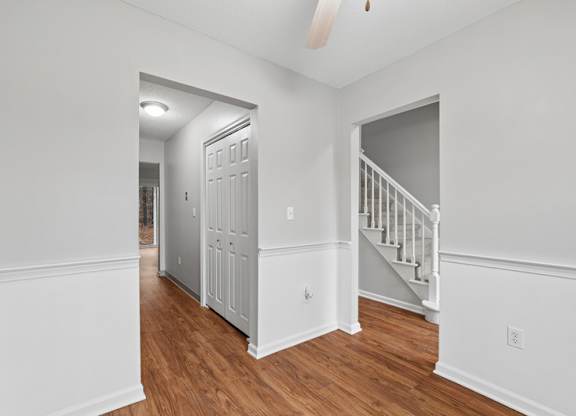 A white interior room with a staircase and a door.