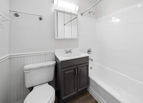 A white toilet sits next to a sink in a bathroom.