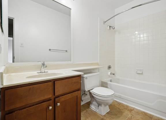 A white bathroom with a toilet, sink, and bathtub.
