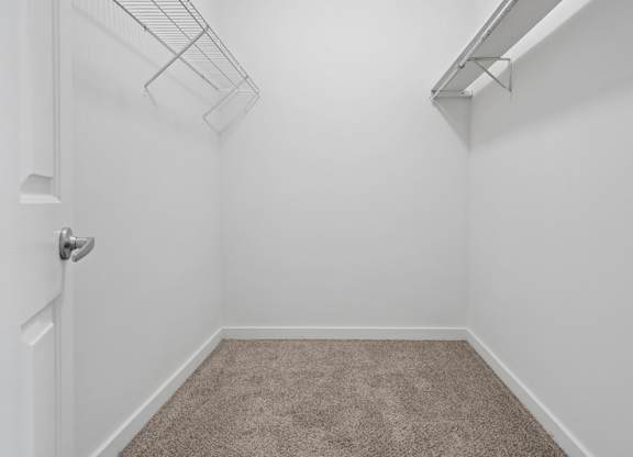 A white room with a carpeted floor and a white door.