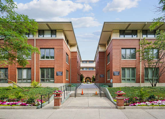 A building with a red brick facade and a green lawn in front.