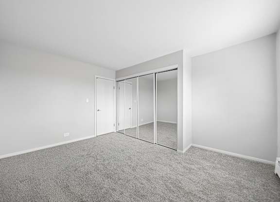 A room with a grey carpet and a white door.