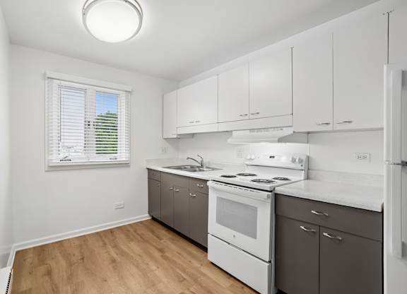 A white kitchen with a stove, oven, and refrigerator.