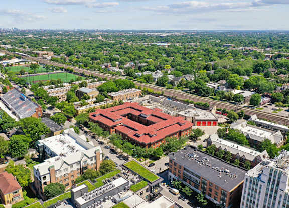 A bird's eye view of a city with a large red building in the center.