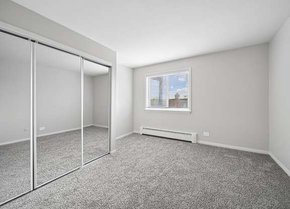 A room with a window and a radiator on the wall.
