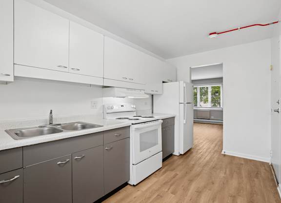 A kitchen with white cabinets and a window.