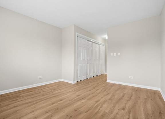 A room with wooden flooring and a white door.