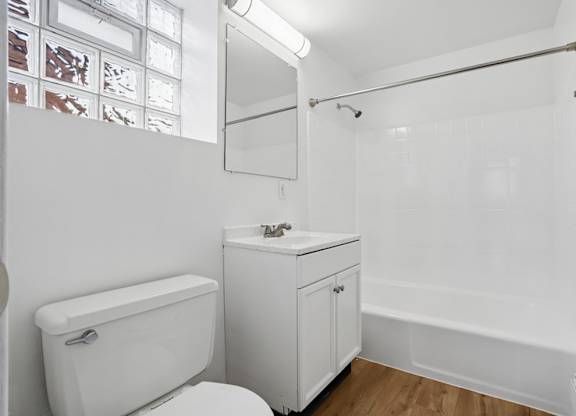 A white bathroom with a toilet, sink, and bathtub.